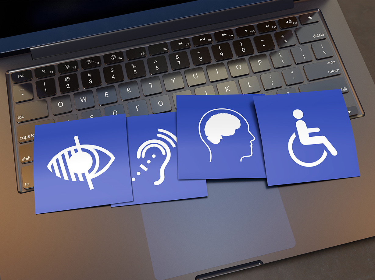 A laptop with signs from different areas of perception related to accessibility
