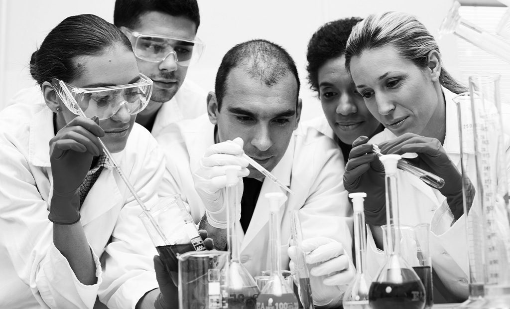 Stock photo of 5 scientist mixing random fluids