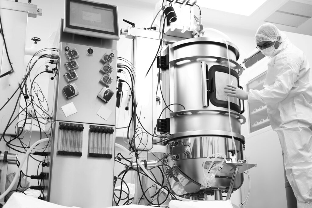 Biomanufacturing scientist uses bioreactor in bioprocess